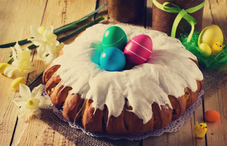 Traditional Easter food cake: the dough wrapped in a roll with nut filling and raisins, with sweet icing. Festive Easter table.の写真素材