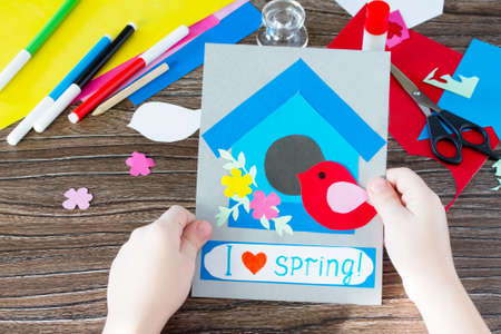 The child create a spring greeting card paper bird and birdhouse. Made by hand. Craft for kids. Children's Art Project, needlework, crafts for children.の写真素材