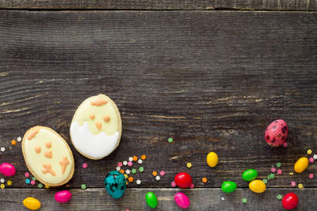Easter frame. Cookies Easter eggs and sugar confectionery sprinkling on a wooden table. Easter recipe. Copy space.の写真素材