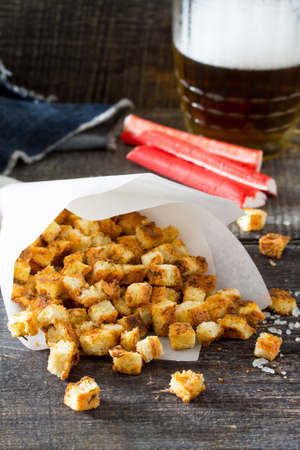 Crab crackers in a paper bag on a wooden table. Snack food to beer.の写真素材