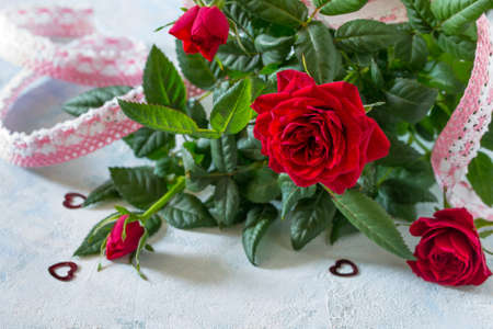 Background wedding, mother's day or birthday. A bouquet of fresh red rose flowers on a blue background.の写真素材