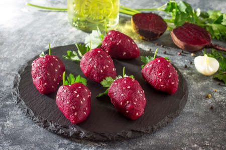 Vegan strawberry snack of boiled beets stuffed with herring on a slate board. healthy eating concept.の写真素材