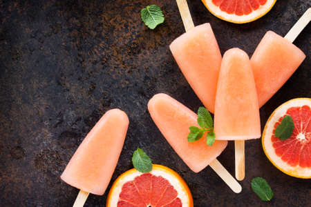 Delicious fruit ice grapefruit and mint on a stone background. Top view with copy space.の写真素材