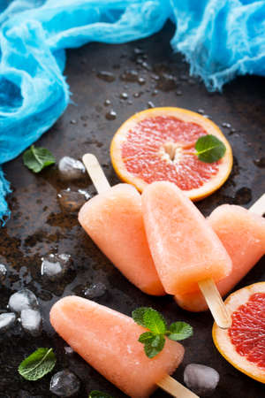 Delicious fruit ice grapefruit and ice on a stone background.の写真素材