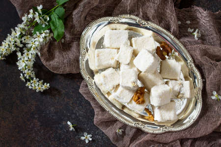 Rahat Lokum with walnuts on the kitchen table. Turkish and Arabic sweets. Ramadan food. Top view....