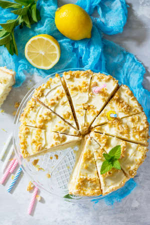 Delicious birthday cake lemon biscuit and butter cream, walnut roasted. Serving of a festive table.の写真素材