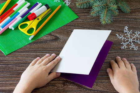 The child adds a birthday card with Christmas presents. Made by own hands. Children's art project, craft for children. Craft for kids.の写真素材