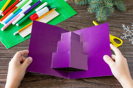 The child adds a birthday card with Christmas presents. Made by own hands. Children's art project,...