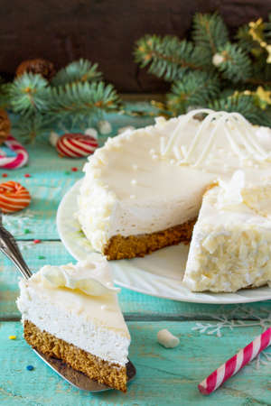 Birthday cake with white chocolate icing on a festive Christmas table. Copy space.