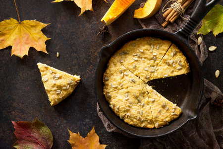 Pumpkin scones on a rusty stone or slate background, top view with copy space.
