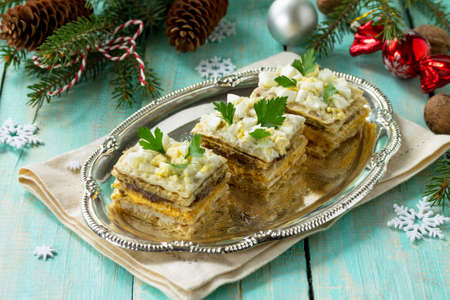 Home holiday snacks Christmas table. Snack cake with a cracker, herring pate, mushroom pate and cheese sauce. Top view with copy space.の写真素材