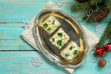 Home holiday snacks Christmas table. Snack cake with a cracker, herring pate, mushroom pate and cheese sauce. Top view with copy space.の写真素材