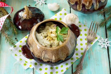 A festive dinner at the Christmas table. Pelmeni baked in a pot with mushrooms and sour cream sauce.の写真素材