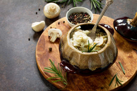 Dumplings baked in a pot with mushrooms and sour cream sauce on a stone or slate background.の写真素材