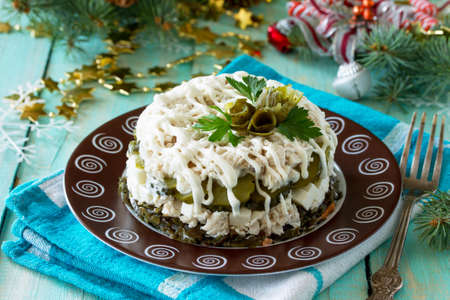 Homemade appetizer on a festive Christmas table. Salad with chicken, rice and sea cabbage.の写真素材