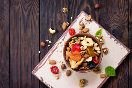 Mix of dried fruits and nuts on a wooden background. The concept of the Jewish holiday Tu Bishvat....