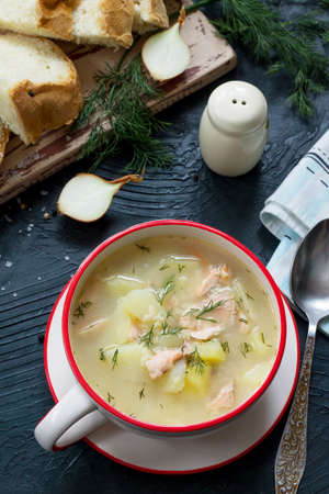 Finnish fish soup with red fish with spices and fresh dill on a dark stone background.の写真素材