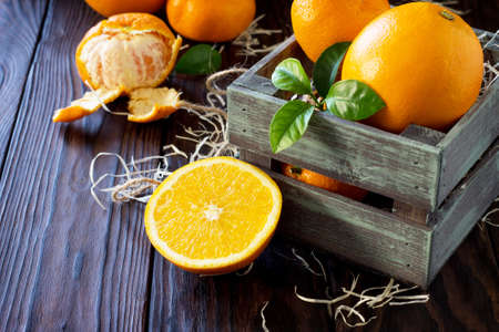 Fresh and juicy oranges and tangerines on a wooden table. Still life, diet and nutrition concept.の写真素材