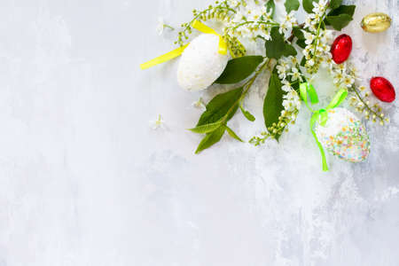 Easter background. Colorful Easter background with colored eggs and sweets on a gray stone background with copy space. Flat lay. Top view with copy space.の写真素材