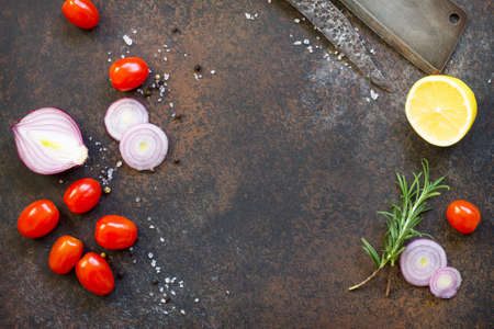 Culinary background with cherry tomatoes, onions, fresh rosemary and spices. Top view with a copy.の写真素材