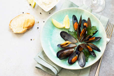 Still life, restaurant dinner.  boiled in white wine sauce with a glass of white wine, white bread...