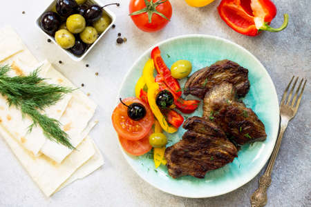 Appetizing barbecue steak from beef sirloin served with fresh vegetable salad. Top view with copy for text.の写真素材