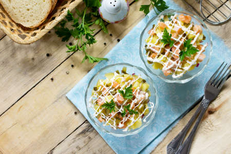 Easter recipe, festive snack. Salad with salmon, pickled cucumber, potatoes and capers - on the festive table. の写真素材
