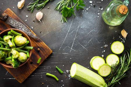 Food background.Various summer green vegetables, spices, olive oil and fresh herbs. Copy space, top view flat lay background.の写真素材