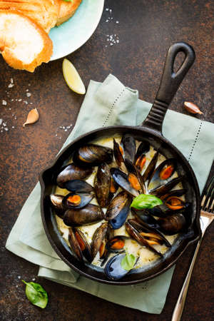 Mussels boiled in a sauce of white wine, served with toast and lemon. Gourmet italian cuisine. Flat lay. Top view.の写真素材