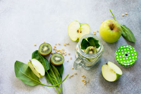 Ingredients for the preparation of green smoothies - apple, kiwi, spinach, pine nuts. Healthy vegan food concept. Copy space.の写真素材