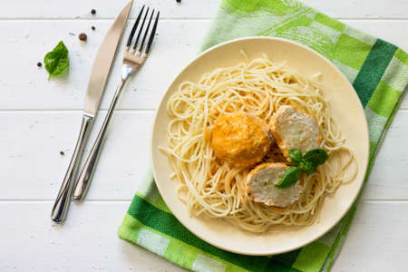 Meat balls turkey with cauliflower in tomato sauce and spaghetti on a wooden table. Top view flat lay background.の写真素材