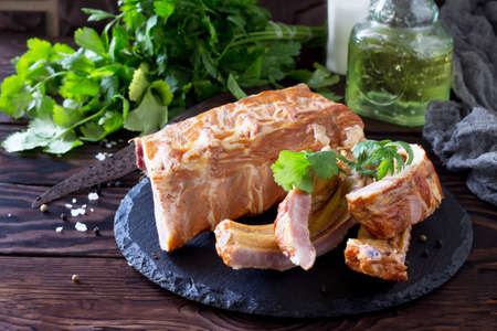 Homemade Smoked Pork Ribs whole and cut in slices on the rustic kitchen table. の写真素材