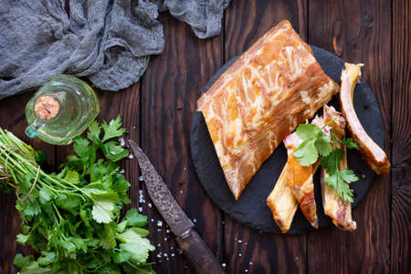 Homemade Smoked Pork Ribs whole and cut in slices on the rustic kitchen table. Copy space, top view flat lay background.の写真素材