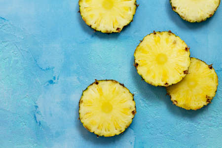 Fresh slice pineapple on stone background or slate with copy space. Food concept. Top view flat lay background.の写真素材