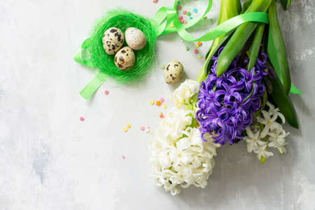 Easter concept. Bouquet of spring hyacinth flower and easter decor on stone background or slate with copy space. Top view flat lay background.の写真素材