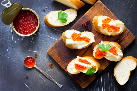 Festive snack. Sandwiches with red caviar, isolated on dark concrete background. Copy space, top view flat lay background.の写真素材