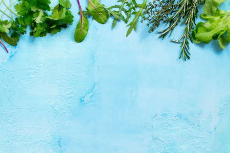 Food background. Diet, concept of vegetarian food. Summer green fresh herbs (parsley, lettuce, rosemary, thyme, arugula and spinach). Copy space, top view flat lay background.の写真素材