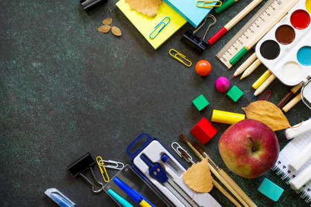 Back to school concept. Items for the school on blackboard dark table. Top view flat lay background,...