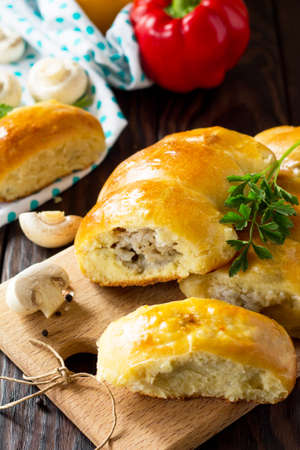 Pies with mushrooms and rice close-yp on the kitchen wooden table. Traditional Russian cuisine.