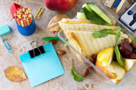 Back to school background with school supplies, sticker, lunch box and apple on concrete or stone background. Copy space.の写真素材