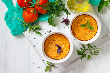 Vegetarian vitamin breakfast French baked cheese souffle with tomato on a wooden table. Vegan dish....