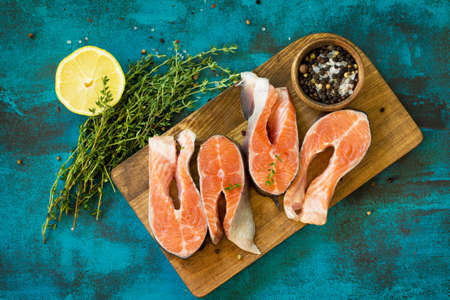 Fresh Fish. Raw Salmon Steak on a blue slate table. Top view flat lay background.