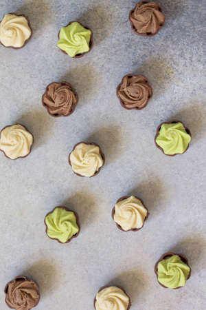 Yummy Assortment chocolate candies. Chocolate with vanilla, chocolate and pistachio cream on marble background. Top view flat lay background.の写真素材