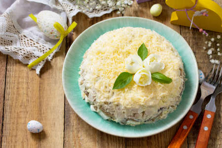 Festive snack on Easter table. Salad with eggs, chicken, mushrooms and cheese. Copy space.