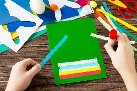 The child glues details an Easter postcard Easter bunny. Handmade. Project of children's creativity,...