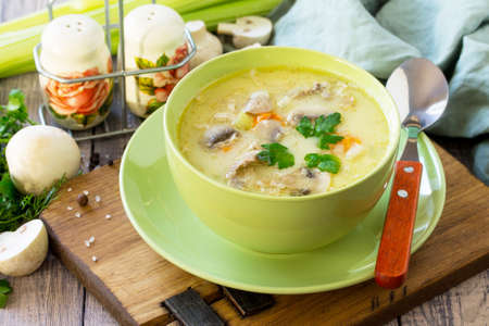 Cream soup with cream, chicken and mushrooms on a rustic-style kitchen table. Copy space.の写真素材