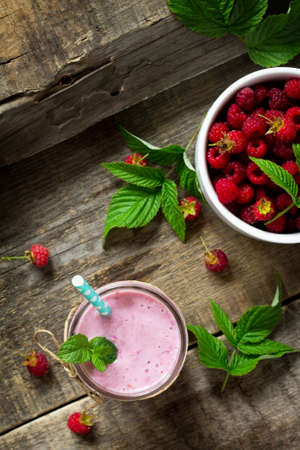 Raspberry fruit Yogurt smoothie or milk shake in glass jar on a wooden rustic table. Natural detox,...