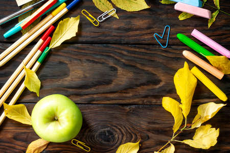 Frame Background Back to school. Table with autumn leaves, apple  and school supplies. Top view flat lay with copy space for your text.の写真素材