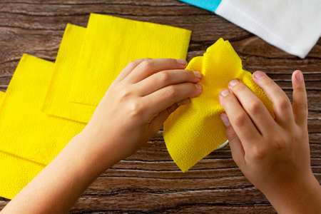 Festive table setting. The child adds a flower from napkins. Handmade. Project of children's creativity, handicrafts, crafts for kids.の写真素材