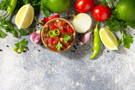 Traditional Latin American mexican salsa sauce with ingredients on a light stone table. Top view flat lay. Free space for text.の写真素材